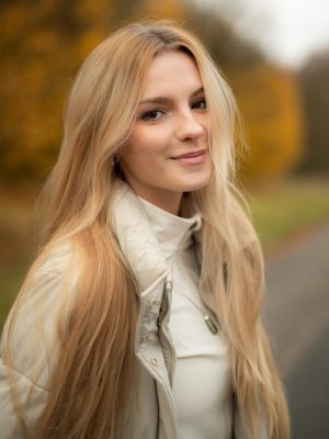 Portrait einer jungen blonden Frau im Herbst.